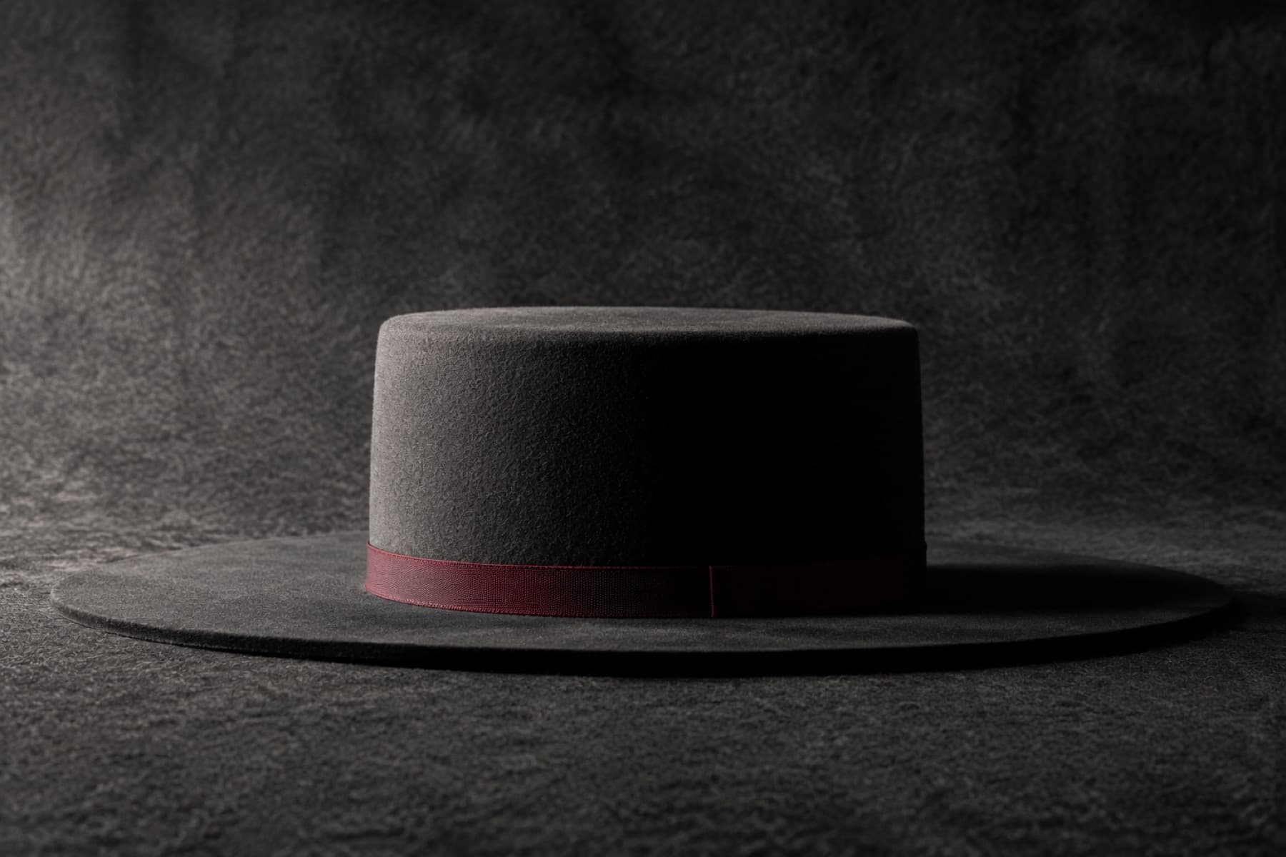 Wide Flat Brim: charcoal felt hat photographed whole under a single hard side light