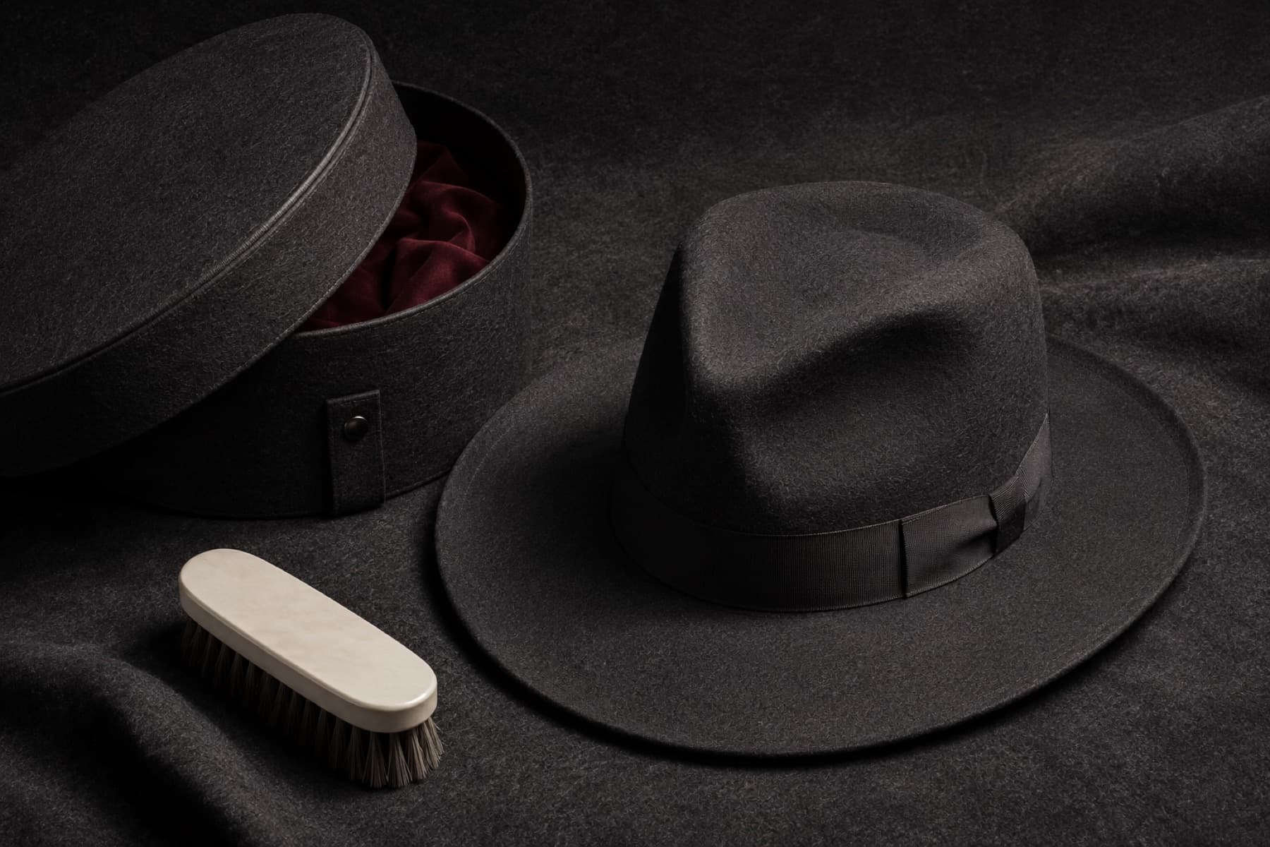 Rabbit felt wide brim hat arranged with a rigid charcoal hat box and a brush